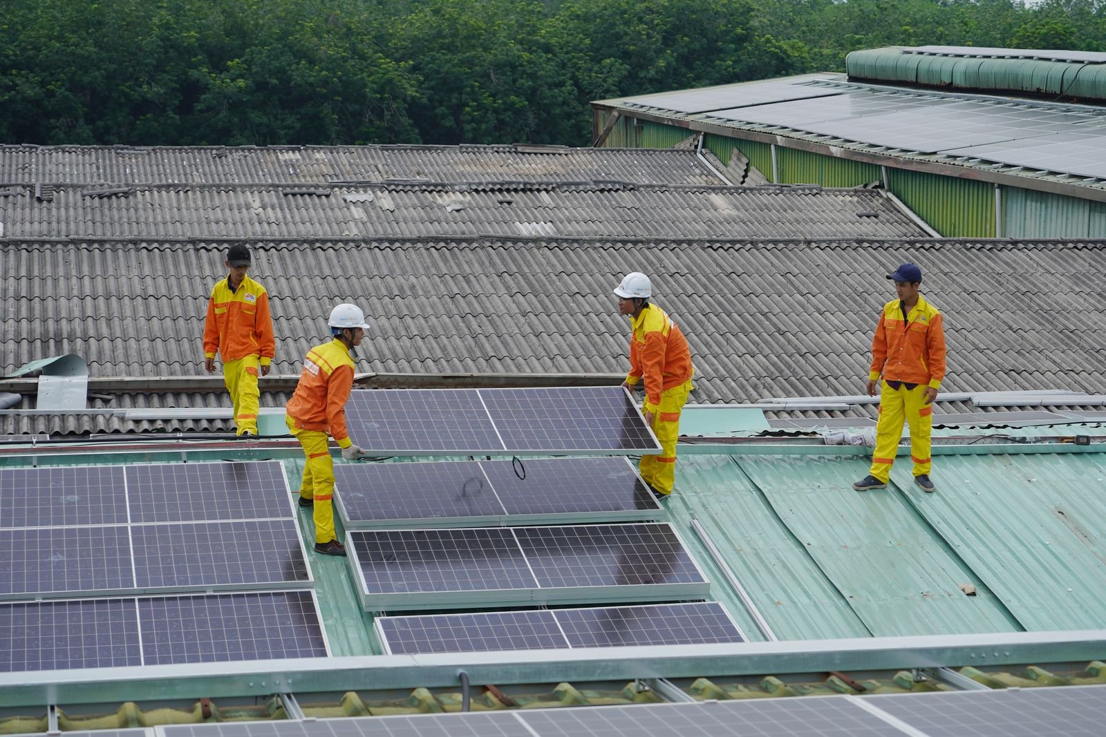 Installation team positioning solar panels on a roof